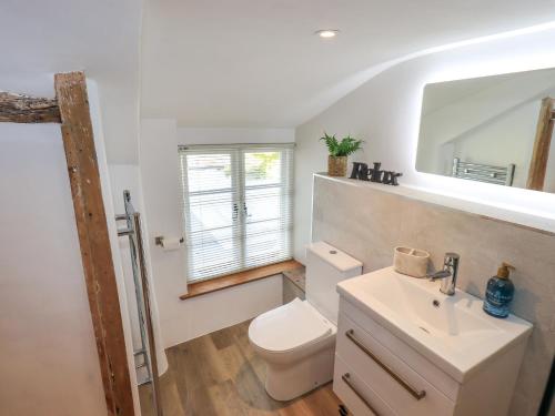 Un baño con un inodoro blanco y un lavabo. en 8 12 Church Street, en Ambleside