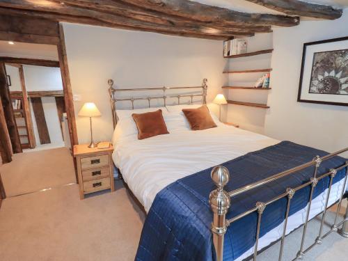 Un dormitorio con una cama grande con una manta azul. en 8 12 Church Street, en Ambleside