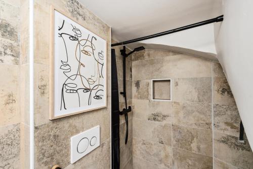 La salle de bains est pourvue d'une douche et d'une peinture murale. dans l'établissement VIEUX CHATEAU II - Agréable 2 pièces - Vue Mer - Menton Vieille Ville, à Menton
