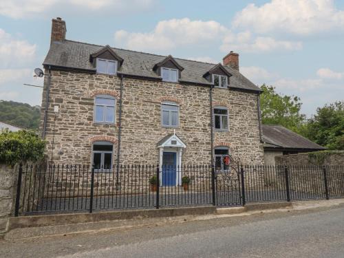 an old stone house with a fence at Upper Dolarddyn in Welshpool