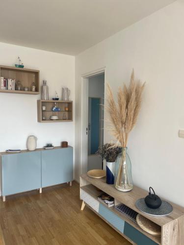 - un salon avec une table et un vase dans l'établissement Appartement cosy cabourg, à Cabourg