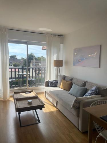 un salon avec un canapé et une table dans l'établissement Appartement cosy cabourg, à Cabourg