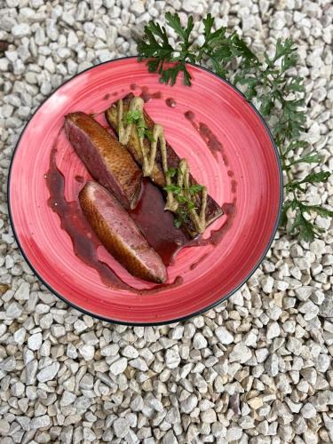 a red plate of food with sausages and vegetables at Hob La Truffière in Gignac