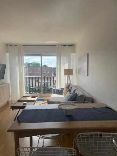 un salon avec un canapé et une table dans l'établissement Appartement cosy cabourg, à Cabourg
