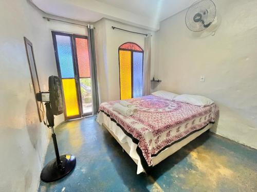 a bedroom with a bed in a room with stained glass windows at Shanti - Hospedagem e Vivências Terapêuticas in Sao Jorge