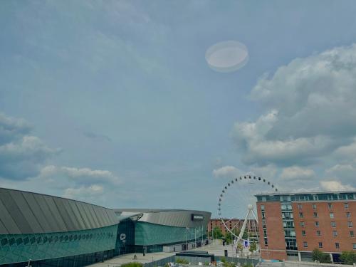 a frisbee is flying in the sky over a city at Monarchs Quay Arena Apartments by Happy Days in Liverpool
