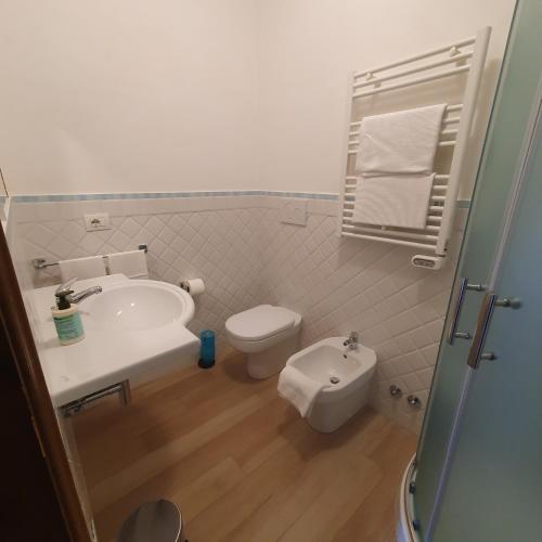 a white bathroom with a toilet and a sink at Agriturismo Costa di Campo in Vernazza