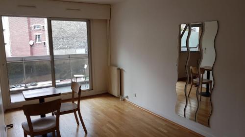 Cette chambre comprend une table, des chaises et un miroir. dans l'établissement Glow and Rest, à Saint-Ouen