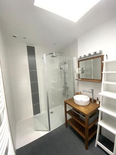 une salle de bain blanche avec une douche et un lavabo dans l'établissement Villa de la Pointe, à Saint-Pabu