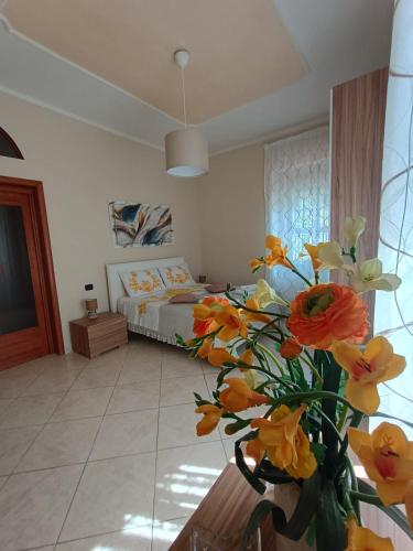 a bedroom with a bed and a vase of flowers at Domus Mirabilis in Torre del Greco