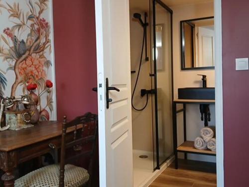 a room with a bathroom with a sink and a table at Domaine des Pommiers in Magnac-Laval