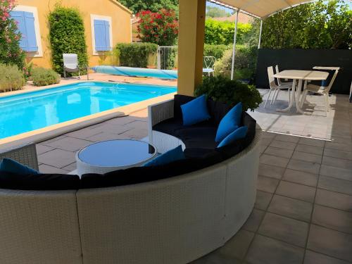 une terrasse avec une piscine, une table et des chaises dans l'établissement L'olivier, à LʼIsle-sur-la-Sorgue