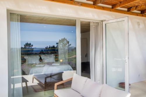 a living room with sliding glass doors leading to a patio at Vale das Estrelas in São Teotónio