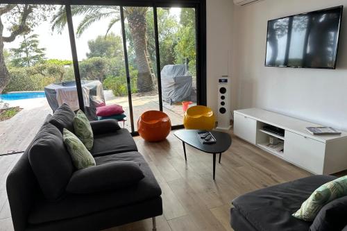 un salon avec un canapé et une télévision à écran plat dans l'établissement Villa 4p with private pool near the sea, à Saint-Raphaël