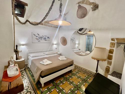 a small bedroom with a bed and a mirror at L'Antica Rimessa Da Gigi in Gallipoli