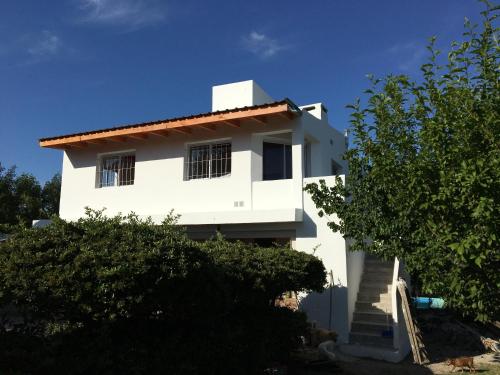 a white house with stairs in front of it at Complejo BIALET MASSE in Bialet Massé