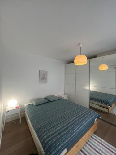 une chambre avec un grand lit et deux lampes dans l'établissement Appartement, à Boulogne-Billancourt