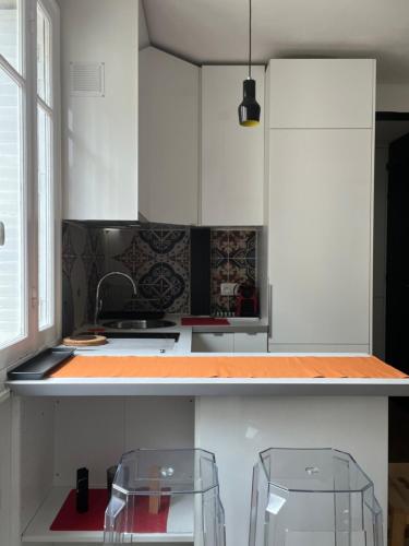 une cuisine avec des armoires blanches et un comptoir dans l'établissement Appartement, à Boulogne-Billancourt