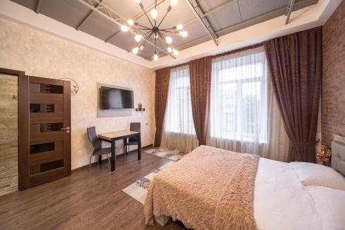 a bedroom with a bed and a desk and a television at Apartment on Sumskaya 46 "Central Residence" in Kharkiv