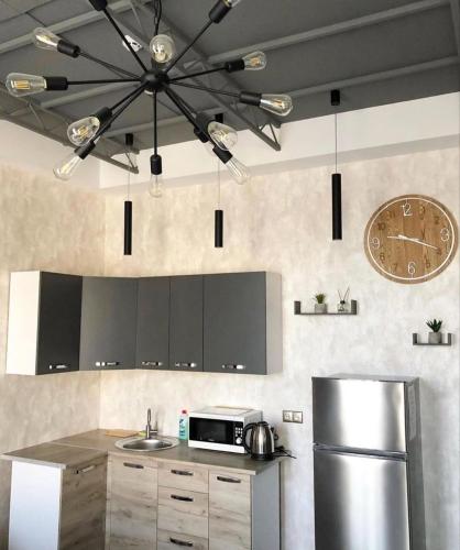 a kitchen with a refrigerator and a clock on the wall at Apartment on Sumskaya 46 "Central Residence" in Kharkiv