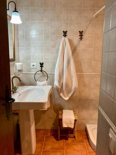 a bathroom with a sink and a towel hanging on the wall at Casa Parranxo in Senterada