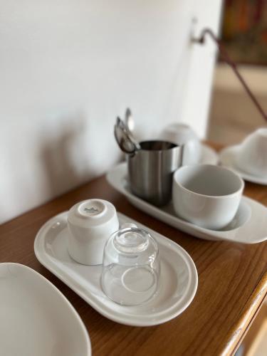 a wooden table with white plates and bowls on it at novarasanmartino22 in Novara