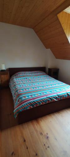 a bed with a colorful comforter in a bedroom at Charmante Bergerie restaurée in Cazaux-Debat