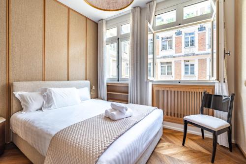 une chambre avec un lit, une chaise et une fenêtre dans l'établissement Prestigious apartment, Eiffel Tower, à Paris