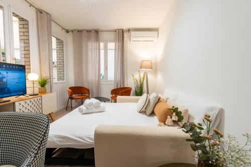 ein weißes Schlafzimmer mit einem Bett und einem Fernseher in der Unterkunft Apartamento de 1 dormitorio cerca de Plaza España-Madrid Temporal PEZ14 in Madrid