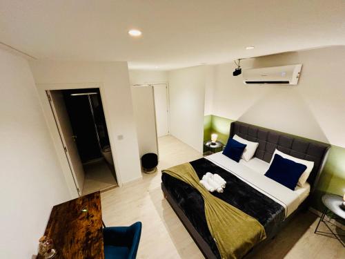 a bedroom with a bed with blue pillows and a table at Refugio do Gato in Palmela