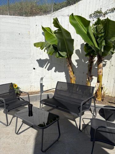 a group of chairs and tables next to a wall at Villa Gabry in Capo dʼOrlando