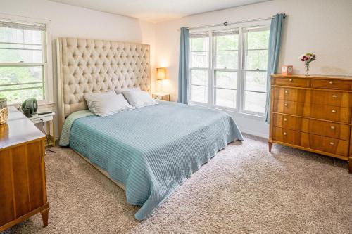una camera con un letto e due finestre e un comò di Pet-Friendly St Paul Home Fireplace and Office Area a Mendota