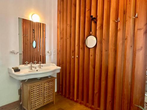 La salle de bains est pourvue d'un lavabo et d'un mur en bois. dans l'établissement Loft transversant avec balcon, à Avignon