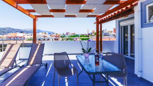 a patio with a table and chairs on a balcony at Nicole Rooms in Palaiochóra