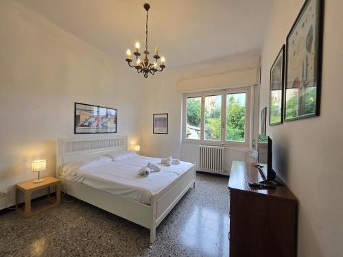 a bedroom with a white bed and a chandelier at Eden - By Ligooria in Pietra Ligure