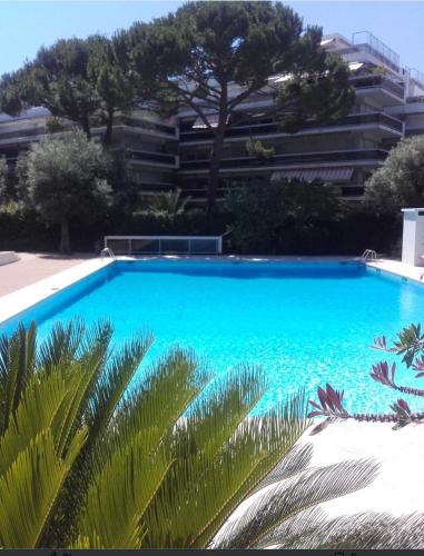 une grande piscine bleue devant un immeuble dans l'établissement Appart 2 pièces, Juan les Pins, plage 400 m, parking, à Antibes