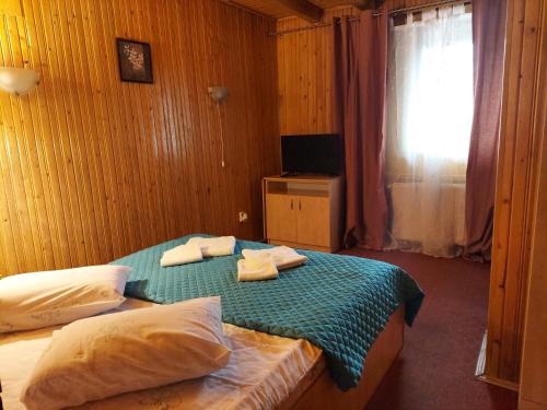 a bedroom with a bed with towels on it at Pensiune Casa Barcaru in Azuga