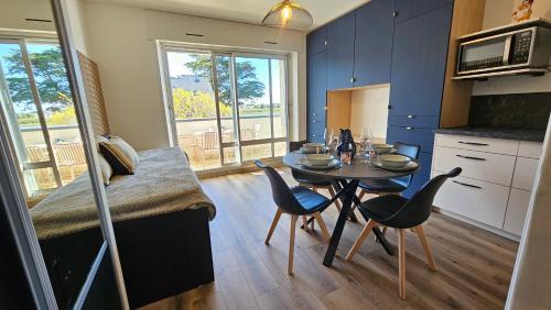 une cuisine avec une table et des chaises dans une pièce dans l'établissement Studio Carnac Plage, à Carnac