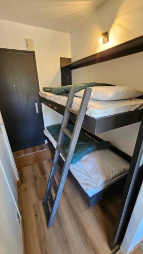 une chambre avec trois lits superposés et une échelle dans l'établissement Studio Carnac Plage, à Carnac