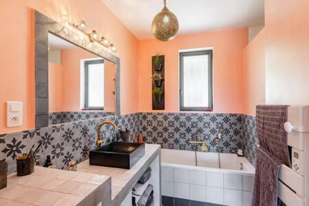 une salle de bain avec une baignoire, un lavabo et un miroir dans l'établissement Propriété vue mer avec jardin et terrasse proche port et calanques, à La Ciotat