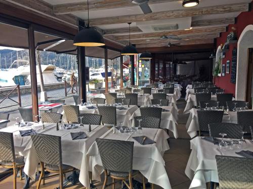 a dining room with tables and chairs with white table cloth at Hotel Restaurant L'Europe in Saint-Florent