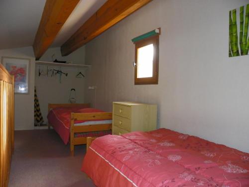 une chambre avec deux lits et une fenêtre dans l'établissement Appartement avec chambre et mezzanine à proximité de la mer, au Cap d'Agde