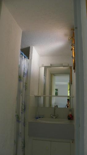 une salle de bain avec un lavabo et un miroir dans l'établissement Appartement avec chambre et mezzanine à proximité de la mer, au Cap d'Agde