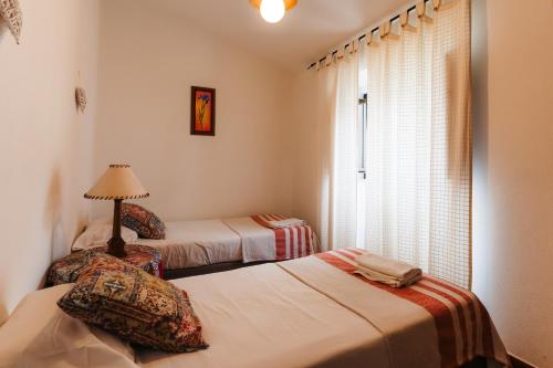 zwei Betten in einem Zimmer mit Fenster in der Unterkunft Apartamento 1 - Fundação de Veiros in Veiros