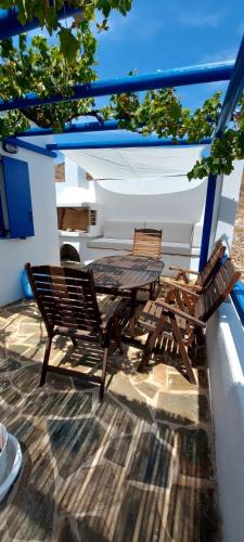 two chairs and a wooden table on a patio at Kouri Escape in Kithnos