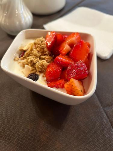 a bowl of food with strawberries and cereal on a table at Agriturismo Colombarola in Sona
