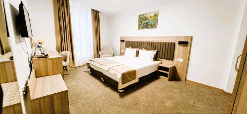 a hotel room with a bed and a television at Evelin Deluxe House in Plovdiv