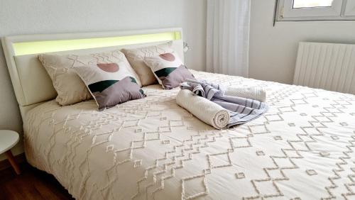 - une chambre avec un lit blanc et des oreillers dans l'établissement Appartement moderne Treeland - Basel - Airport, à Saint-Louis