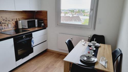 une petite cuisine avec une table et un micro-ondes dans l'établissement Appartement moderne Treeland - Basel - Airport, à Saint-Louis