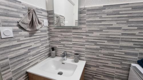 une salle de bain avec un lavabo et un miroir dans l'établissement Appartement moderne Treeland - Basel - Airport, à Saint-Louis